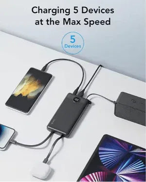 Multiple devices being charged by a power adapter on a white surface.